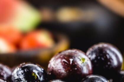 Jaboticaba or jabuticaba, Brazilian and South American fruit, in a clay pot. with tropical fruits in the background.