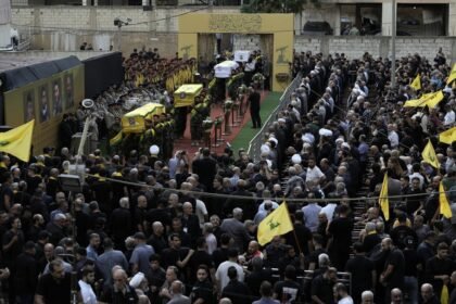 Combatentes do Hezbollah carregam os caixões de quatro mortos na terça-feira depois que seus pagers portáteis explodiram, durante seu cortejo fúnebre no subúrbio ao sul de Beirute — Foto: AP Photo/Bilal Hussein