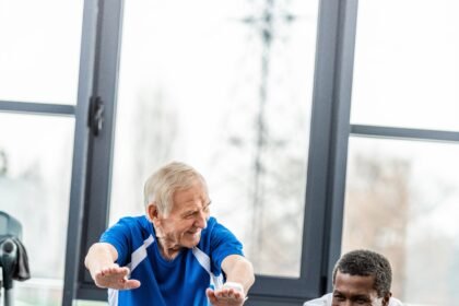 two multicultural mature sportsmen doing squats at gym