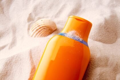 Sunscreen on sand background